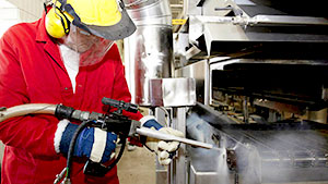 worker cleaning food production equipment with dry ice blasting