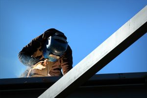 a welder working on a steel frame building