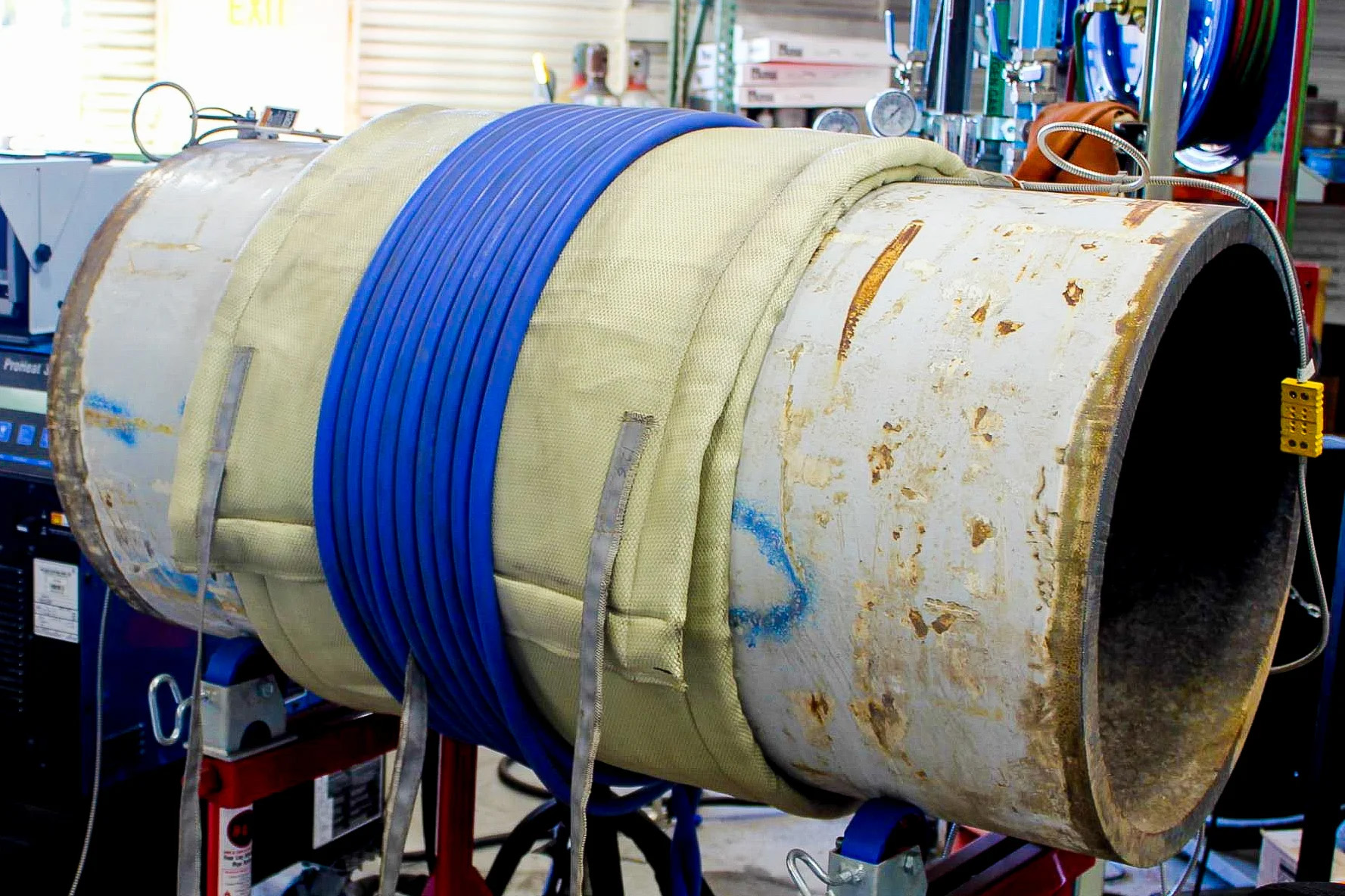 Liquid-cooled induction heating cable wrapped around an insulated pipe section